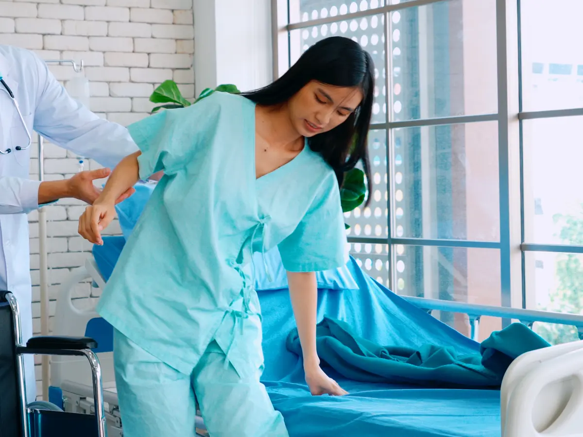 A health care worker helping a person walk with support